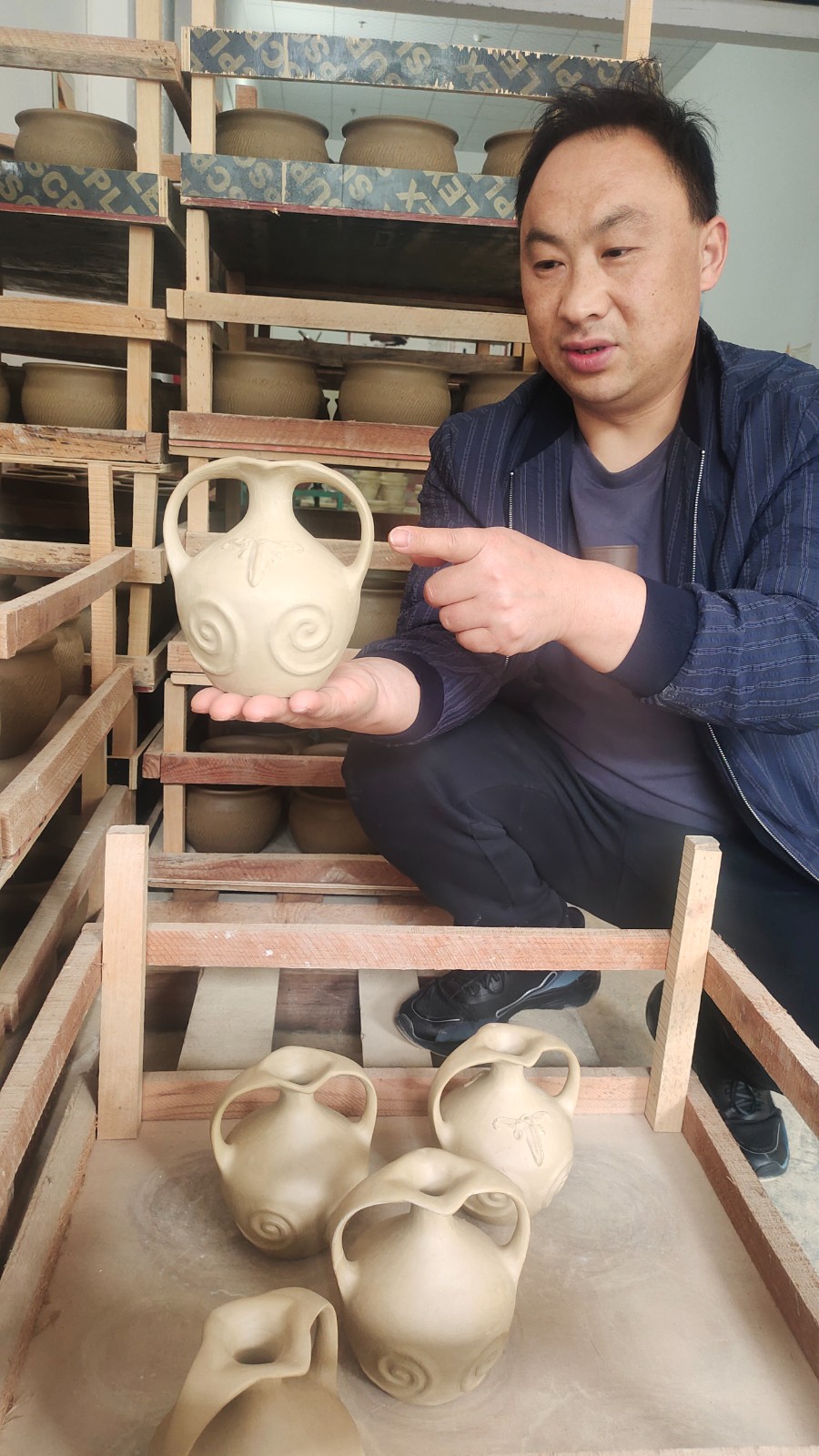 彭加榮展示自己設(shè)計(jì)制作的羌族酒器。.jpg