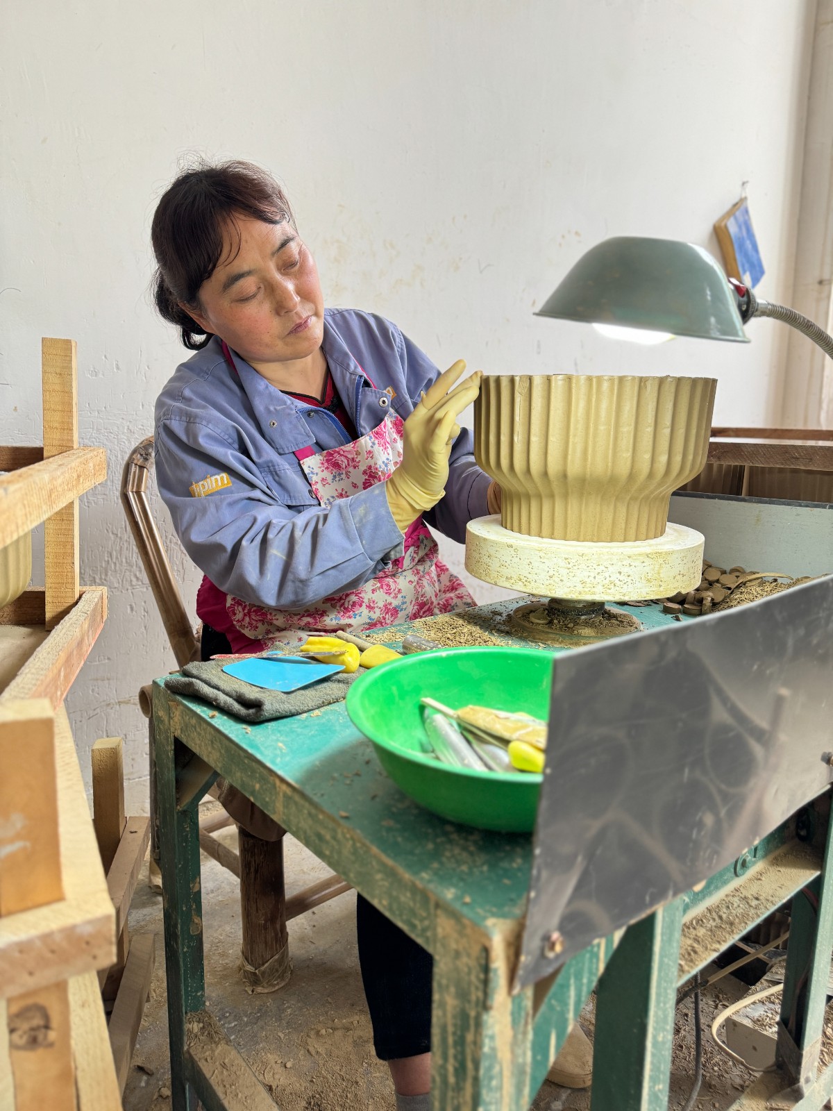 在秦熙禾陶業(yè)有限公司里，女工正在進(jìn)行陶器修胚工序。.jpg